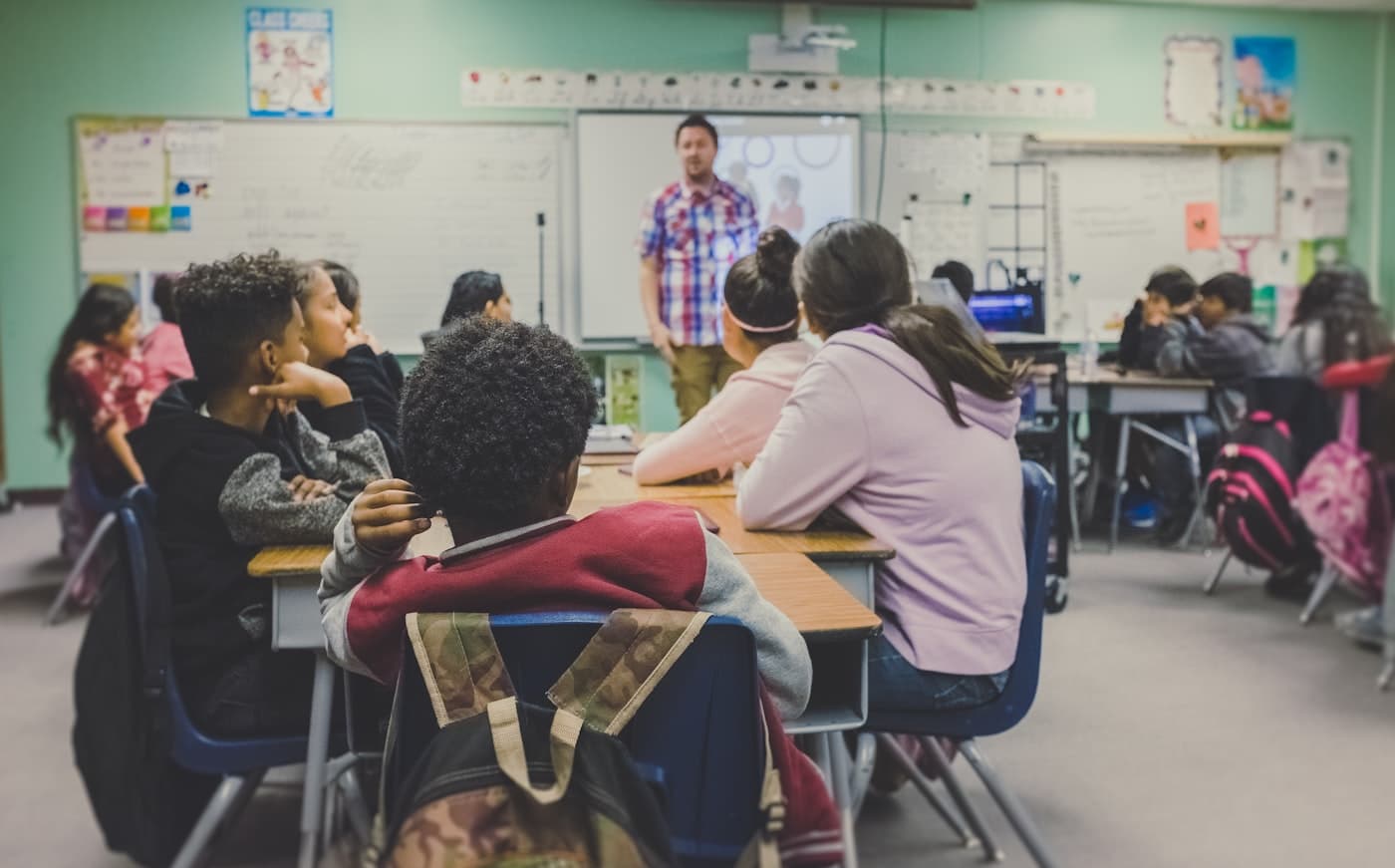 Teacher guiding students in a bright classroom